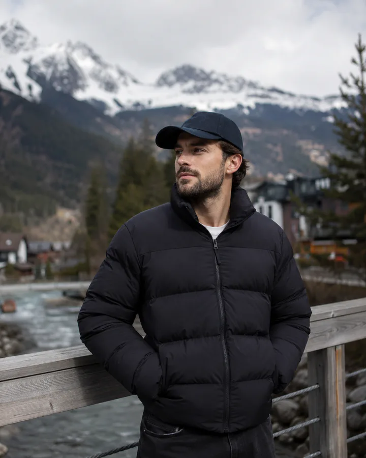 Customer wearing a charcoal puffer jacket in the mountains
